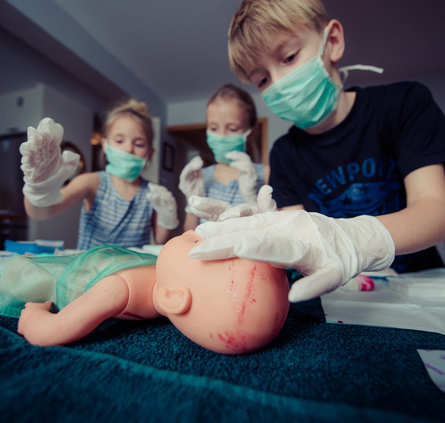 Niños curando a sus muñecos.
